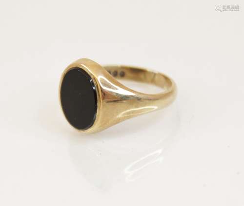 A 9ct gold black onyx signet ring, the oval onyx panel measu...