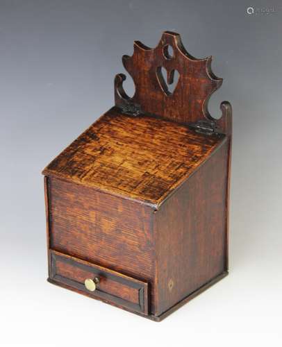 An 18th century oak candle box, the shaped fret work back ce...