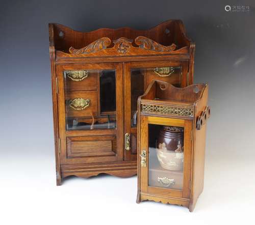 An early 20th century oak smokers cabinet, the carved pedime...