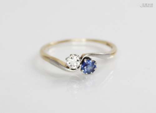 A diamond and sapphire two-stone ring, comprising a round mi...