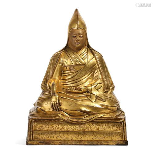 A GILT BRONZE FIGURE OF A SEATED LAMA