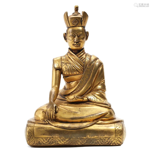 A GILT BRONZE FIGURE OF SEATED GURU