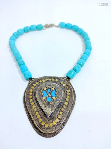 An oval silver pendant with turquoise beads necklace -