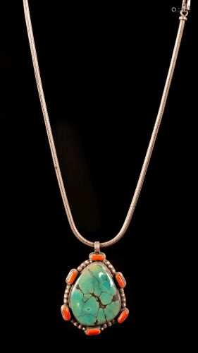 A Turquoise, coral and silver pendant with a silver