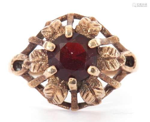 9ct gold and garnet ring centring a round faceted garnet, cl...