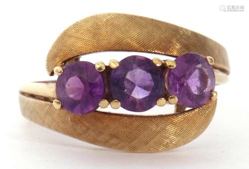 Amethyst set cross-over ring featuring three gold faceted cu...