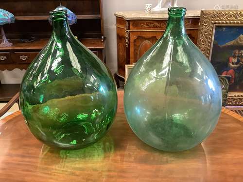 A pair of green glass carboys, height 62cm