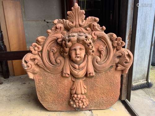 A terracotta cherub head garden wall plaque, width 54cm, hei...