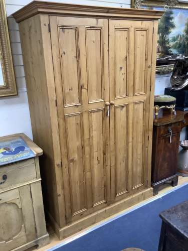 A panelled pine two door wardrobe, length 124cm, depth 59cm,...