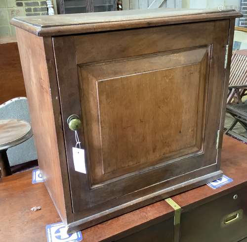 A Victorian mahogany cupboard, enclosed by a panelled door, ...