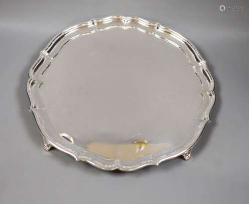 A circular silver salver,having piecrust border on four scro...