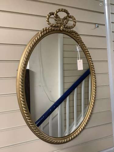A gilt and composite wall mirror with simulated rope twist f...