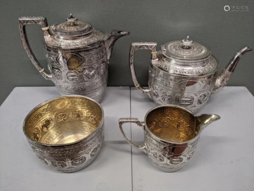 A four piece silver tea set with etched and embossed