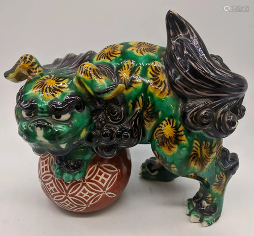 A Japanese sancai glazed pottery dragon on ball, H.18cm