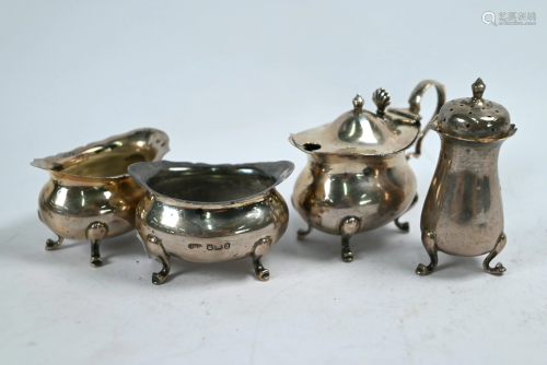 Silver cream jug and various condiments