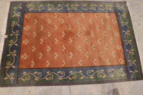 NEPAL. Tapis en laine à fond saumon à décor floral stylisé. ...