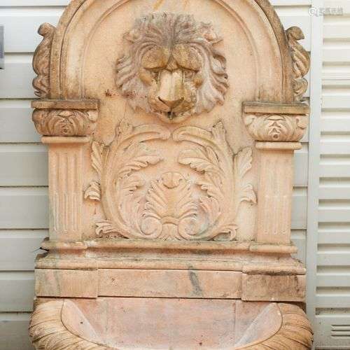 Fontaine en marbre rosé à décor de tête de lion, coquille et...