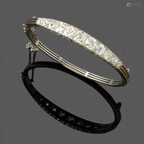 Bracelet jonc ouvrant, vers 1900. En platine, serti sur le d...