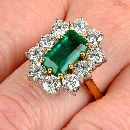 An 18ct gold emerald and brilliant-cut diamond cluster ring....