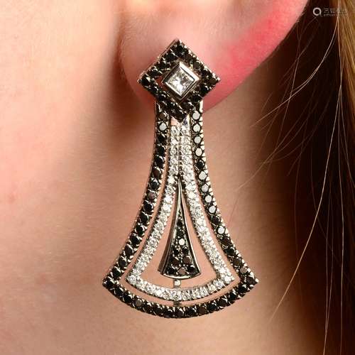 A pair of diamond and black gem earrings.Estimated total dia...