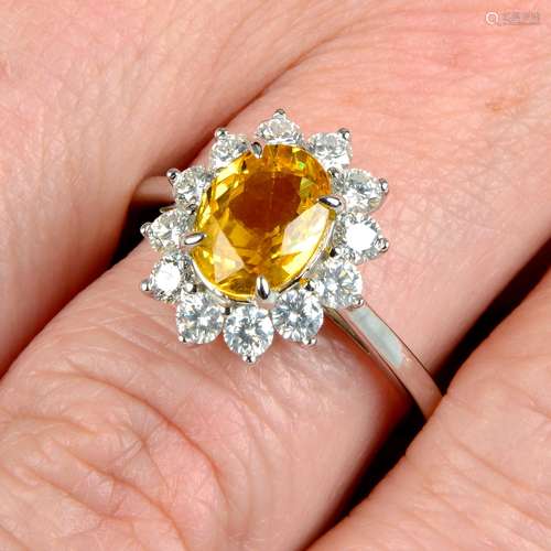 A yellow sapphire and brilliant-cut diamond cluster ring.Sap...