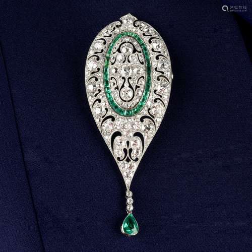 An Art Deco platinum, diamond and emerald, pierced brooch.