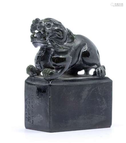 A black and dark green jade seal, carved with a lion crouche...