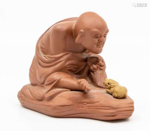 A Chinese Yixing model of a monk and a small recumbent ram, ...