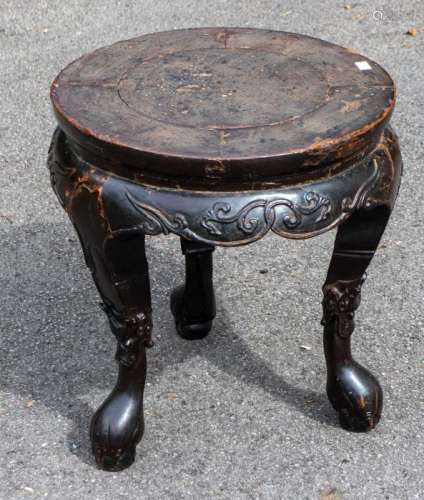 A large Chinese lacquered elm stool, the circular top above ...