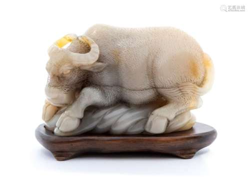 A pale beige and grey soapstone carving of a buffalo, the an...