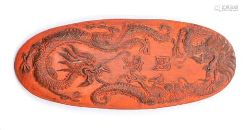 A Chinese cinnabar oval ink cake, Qing dynasty, the upper su...