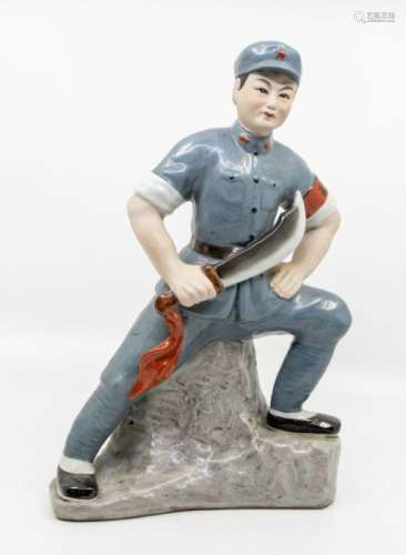 A Chinese Communist porcelain figure, standing with one foot...