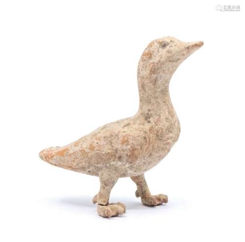 A small Chinese unglazed pottery figure of a duck, standing ...