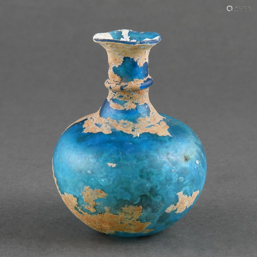 A SMALL BLUE GLASS BOTTLE VASE