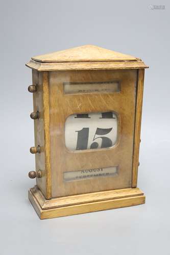 An early 20th century oak desk calendar with apertures, heig...