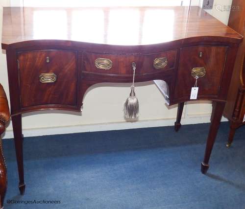 A George III and later mahogany serpentine fronted sideboard...