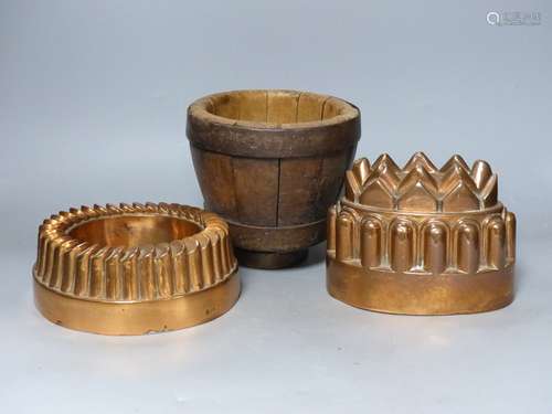 Two 19th century copper jelly moulds, and a wooden mortar, t...