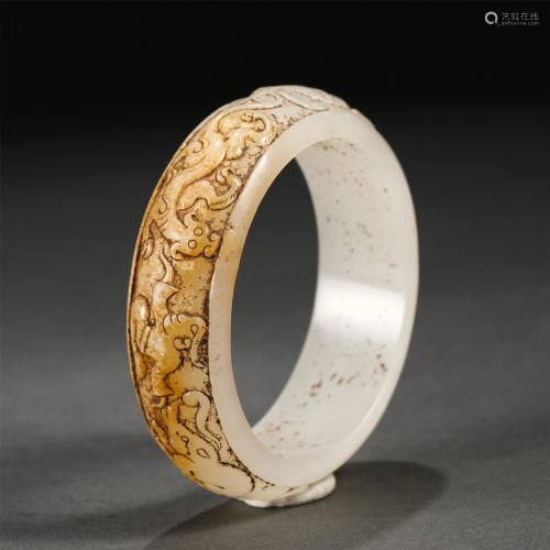 A CHINESE CARVED BEASTS JADE BANGLE