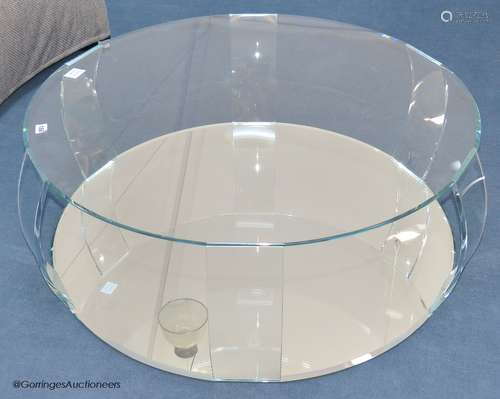 A contemporary glass circular coffee table, with mirrored ba...