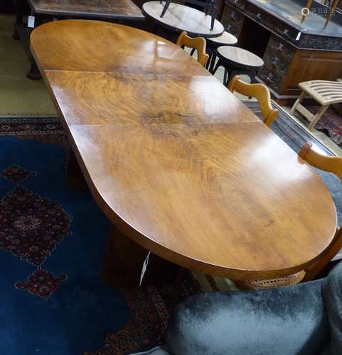 An Art Deco figured walnut extending dining table with one l...