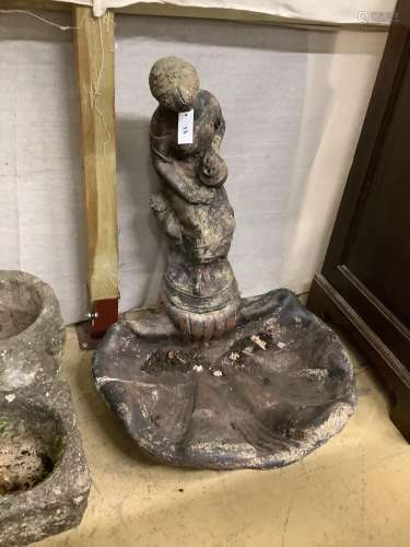 A reconstituted stone scallop shape bird bath with figural t...