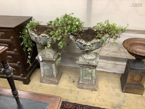 A pair of reconstituted stone garden urns on pedestals, heig...