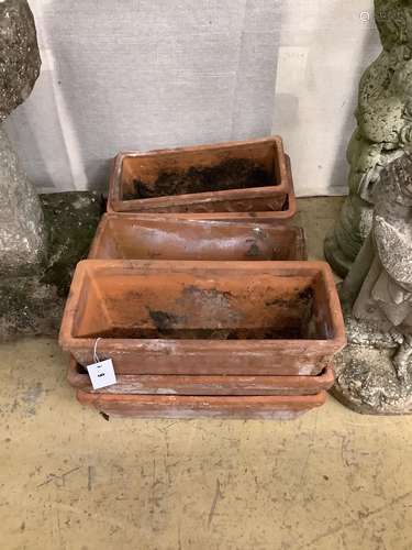 A set of three terracotta garden troughs and four similar tr...