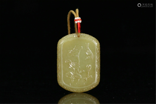 A CHINESE CARVED LOTUS AND BIRD YELLOW JADE PENDANT
