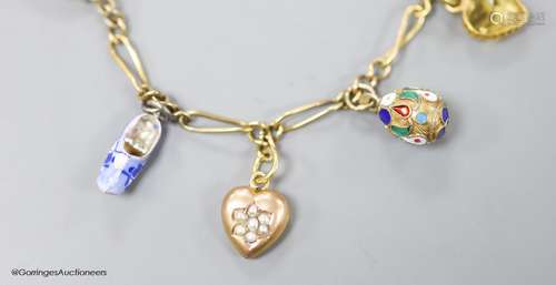 A small Edwardian 9ct gold charm bracelet, hung with eight a...