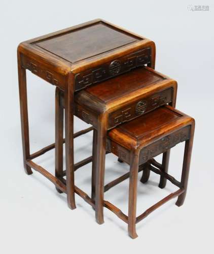 A GOOD NEST OF THREE CHINESE HARDWOOD TABLES, each with carv...