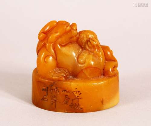 A CHINESE CARVED AMBER COLOUR SOAPSTONE SEAL OF A LION DOG -...