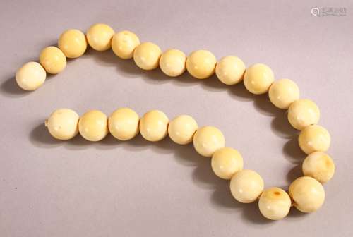 AN IVORY BEAD NECKLACE, comprising 24 spherical beads, large...