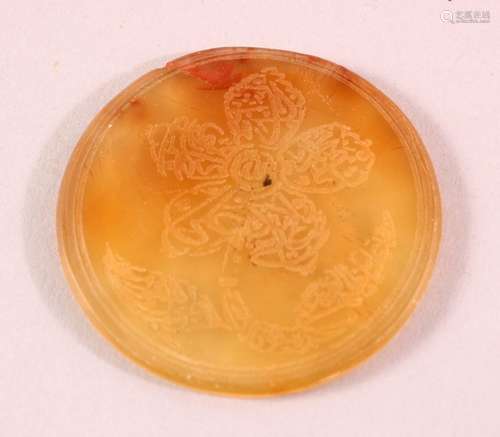 AN ISLAMIC CIRCULAR YELLOW AGATE PLAQUE, with engraved decor...