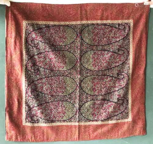 A PAISLEY SHAWL FRAGMENT, possibly Indian, within a cotton p...